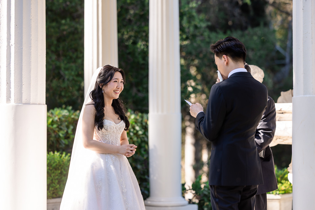 groom saying his personal handwritten wedding vows while wiping away a tear