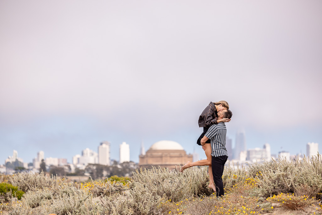 romantic lift up pose with the Palace of Fine Arts and San Francisco downtown as the backdrop