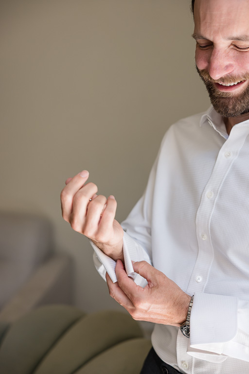 groom putting on cuff links