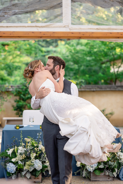 groom romantically picking up the bride and kissing her
