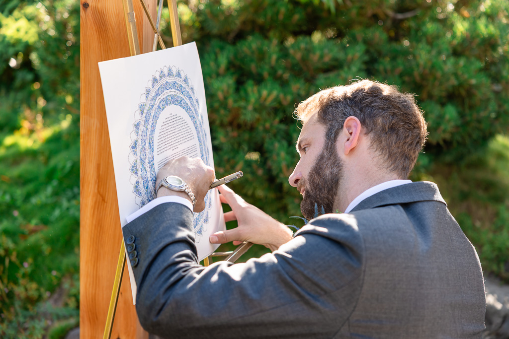 groom signing the Ketubah