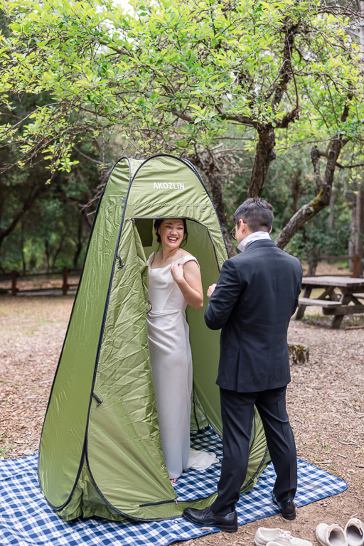 cute candid photo of the bride and groom getting ready in a pop-up changing tent