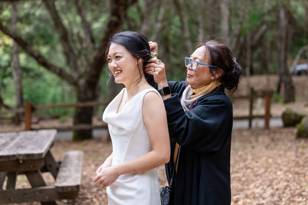 mom helping with bride's floral hair piece
