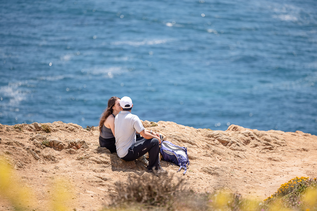 surreptitious photos of couple celebrating their very recent engagement on the cliffs of the Pacific Ocean