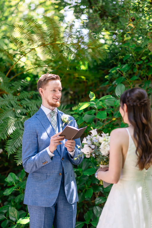 groom reading handwritten private vows to his bride