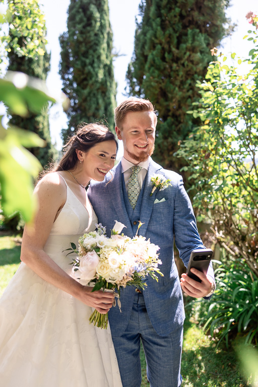 bride and groom taking a selfie on their phone on their wedding day