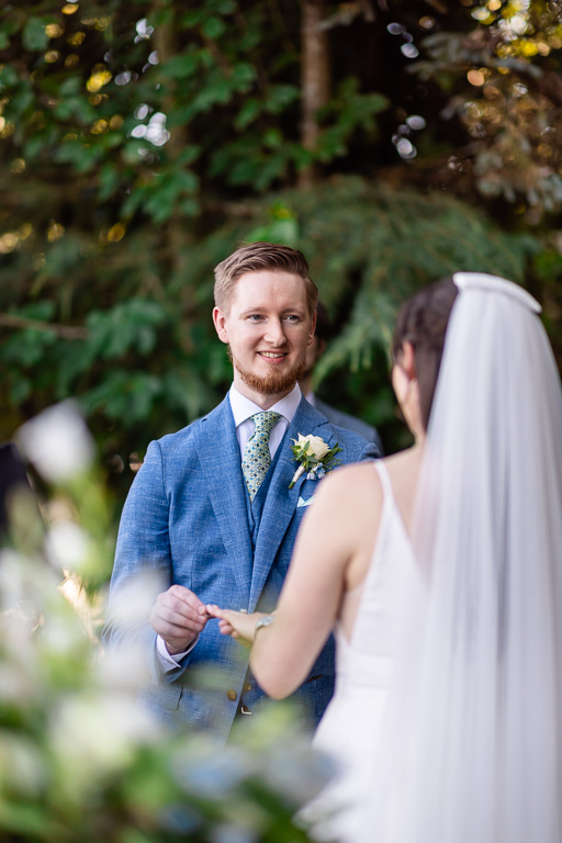 groom putting the ring on his bride's finger