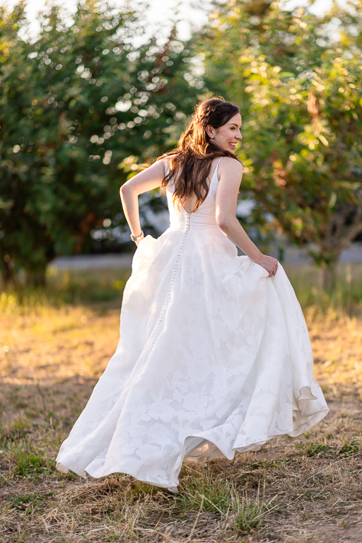 bride running along in the vineyards