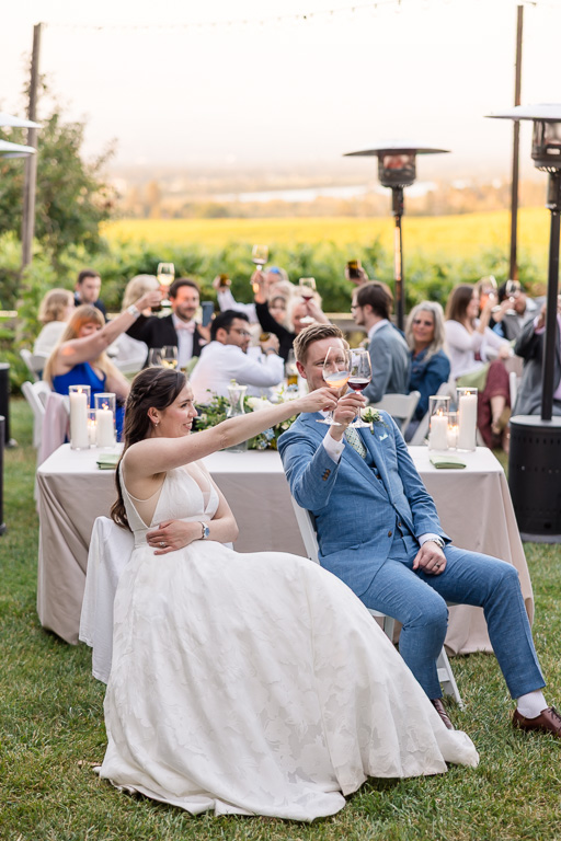 bride and groom clinking their wine glasses