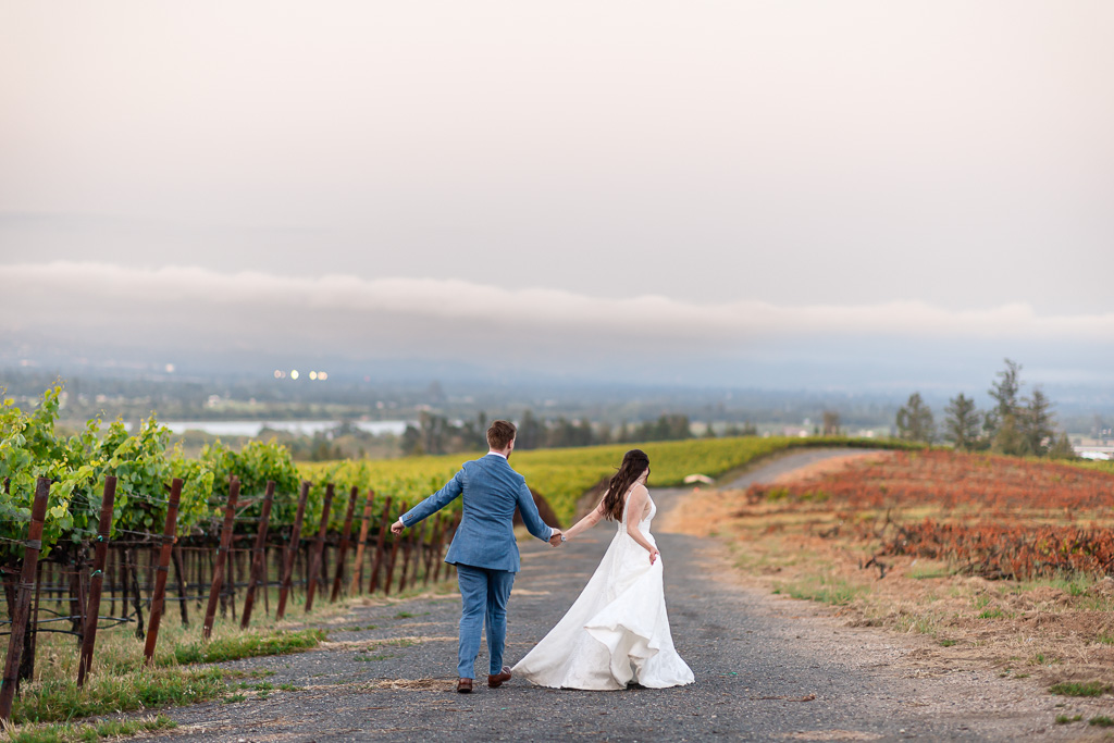 bride and groom running off into the distance along an empty road