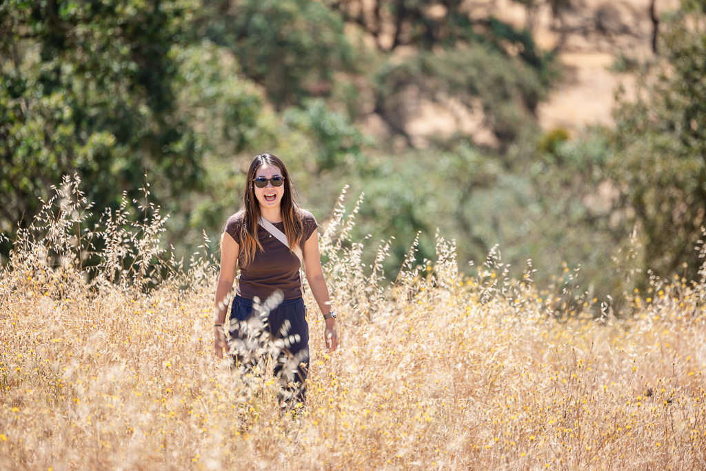 young woman with surprised expression in a field with waist-height golden grass