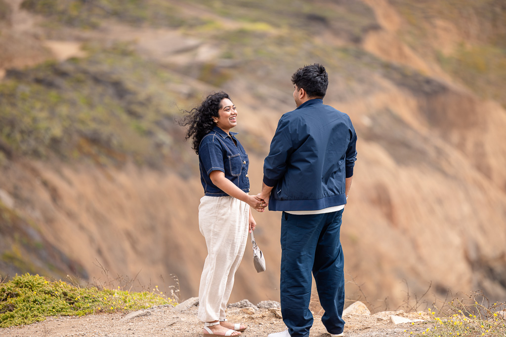 couple talking to each other on a cliffside
