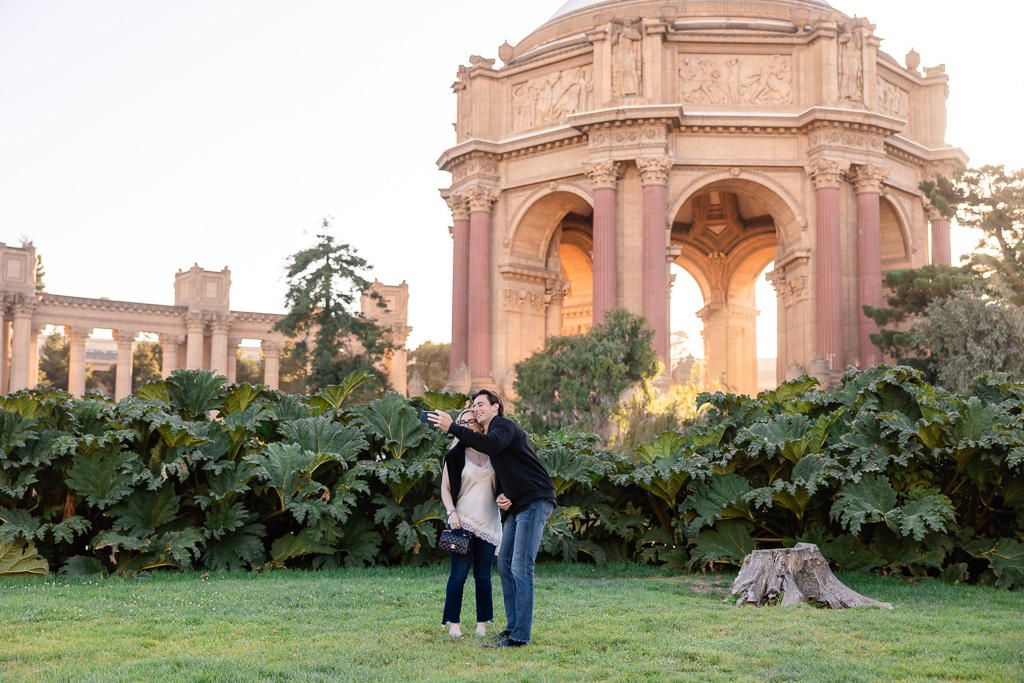 couple taking a selfie on the lawn in front of the Palace of Fine Arts
