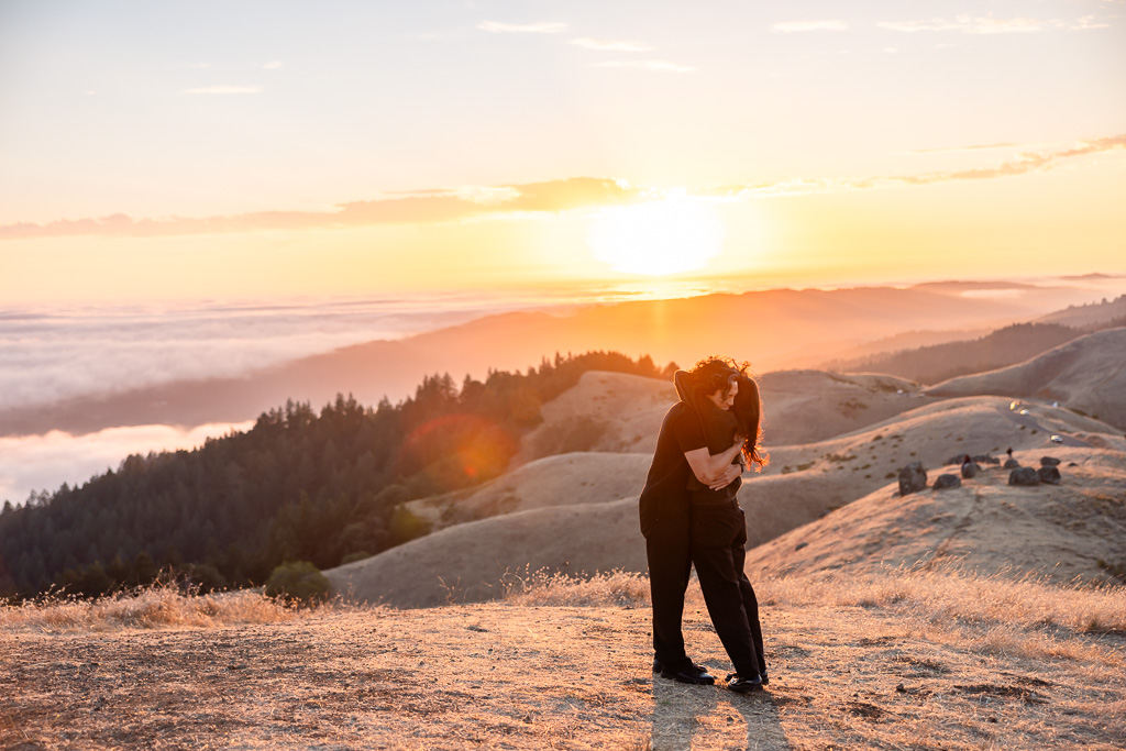 marriage proposal moment on a mountain above a sea of fog below