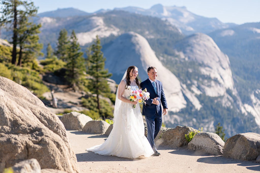 bride walking down the aisle with father at Glacier Point Amphitheater