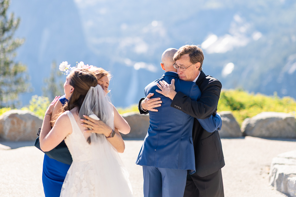 bride and groom hugging their parents after ceremony