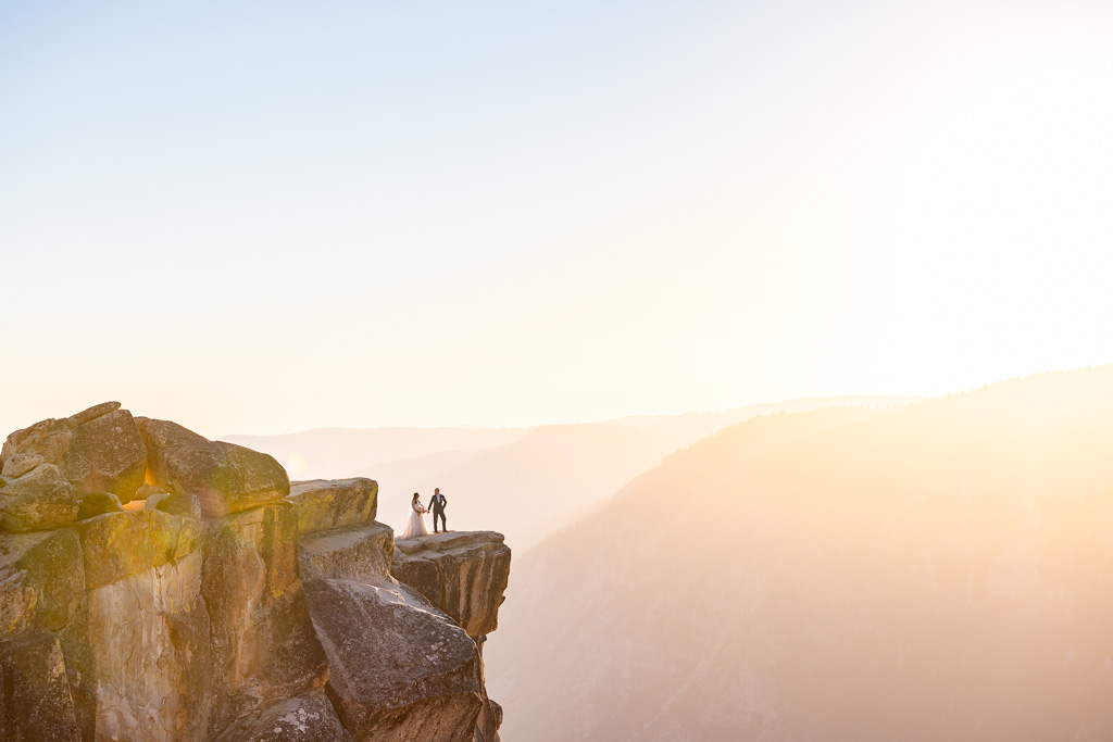 epic faraway shot of bride and groom at the Taft Point cliff at sunset