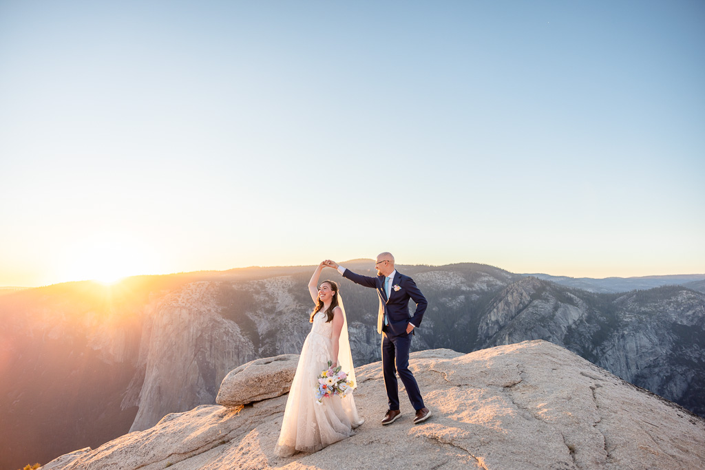 bride and groom dancing in wedding attire at Yosemite National Park during sunset