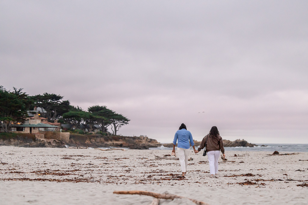 couple walking towards the ocean at dusk