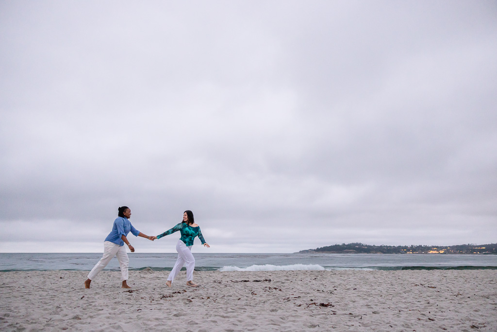 couple running along the beach shoreline