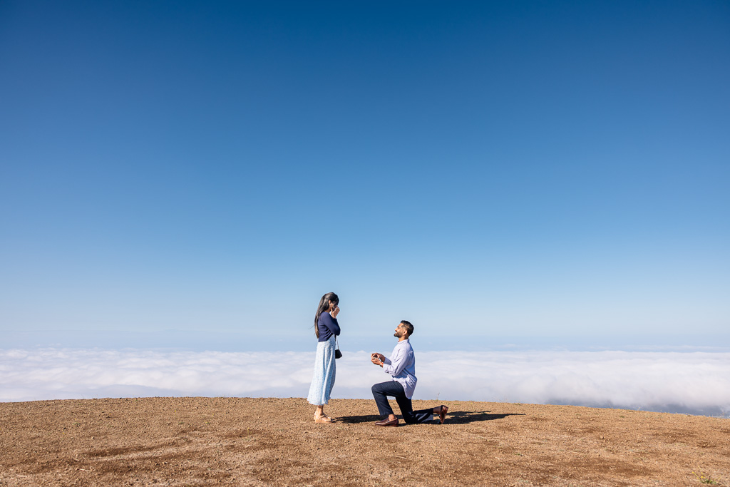 marriage proposal on a mountaintop with a sea of fog below them