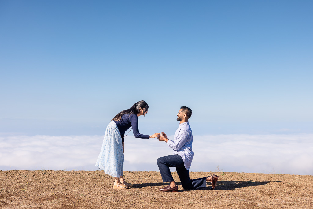 surprise marriage proposal above a sea of low clouds