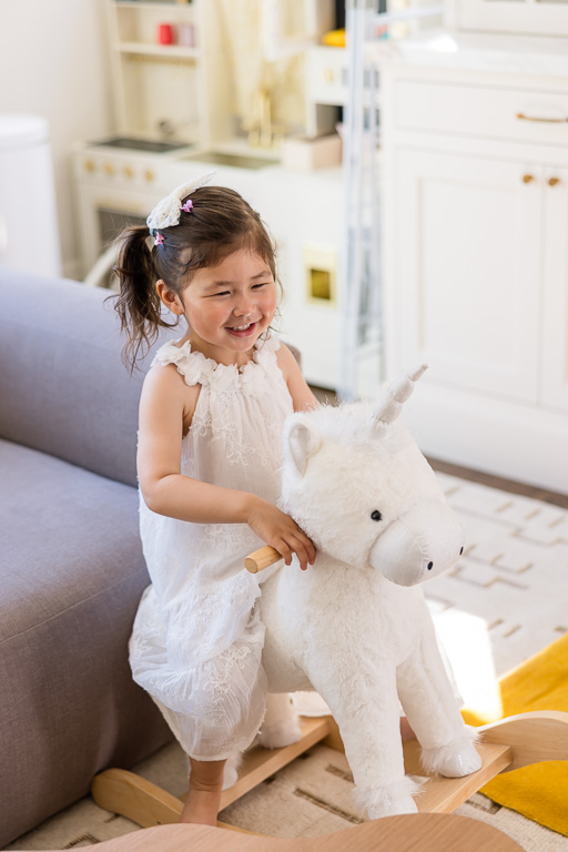 San Francisco in-home family portraits with baby girl and unicorn rocking horse