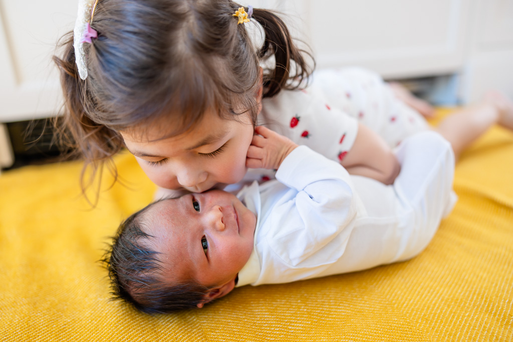 big sister giving little bro a kiss