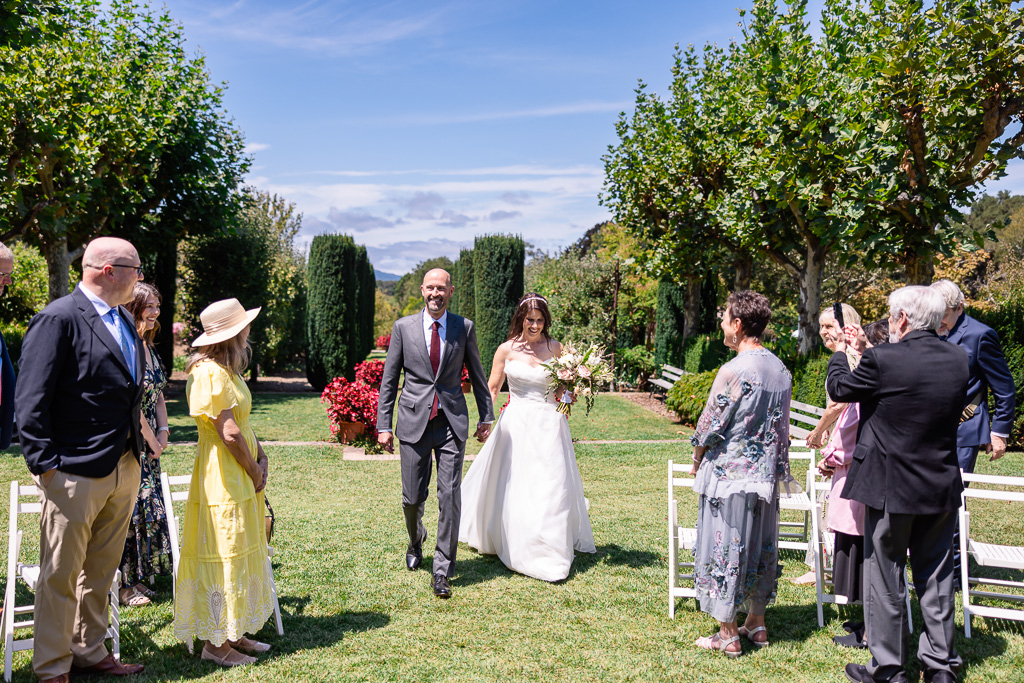 bride and groom entering the wedding ceremony walking up the aisle together at Filoli High Place