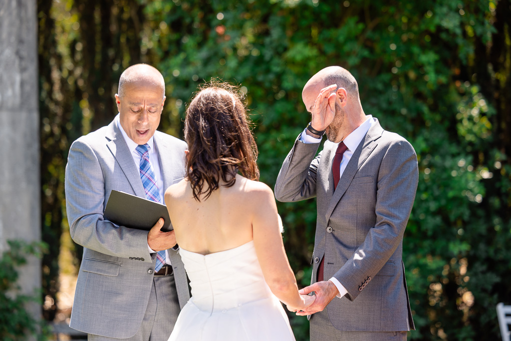 groom wiping away a tear during an emotional wedding ceremony moment