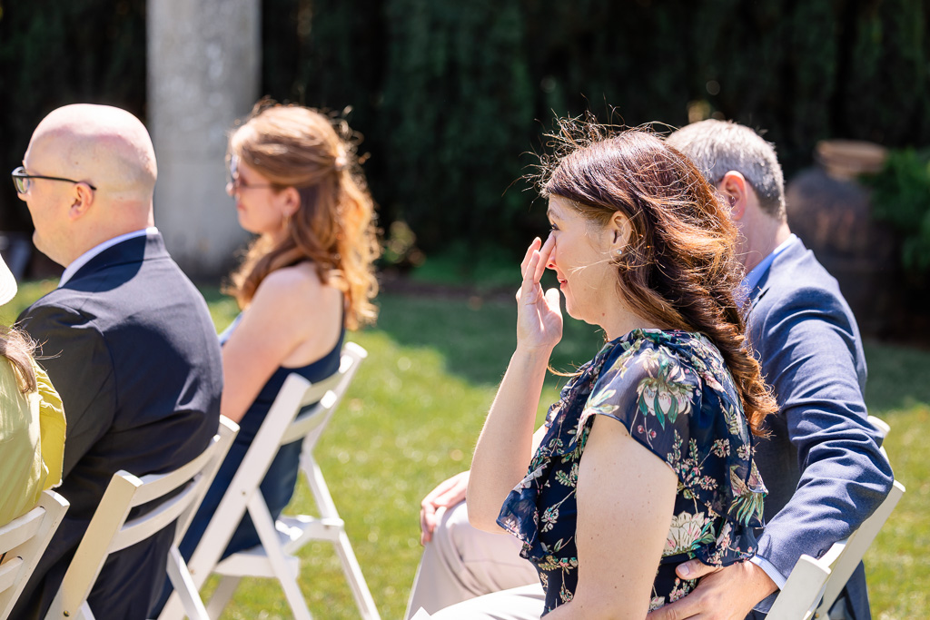 a wedding guest wiping a tear away during the ceremony