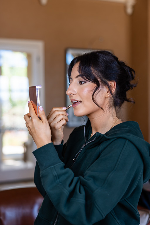 bridesmaid putting on lip gloss