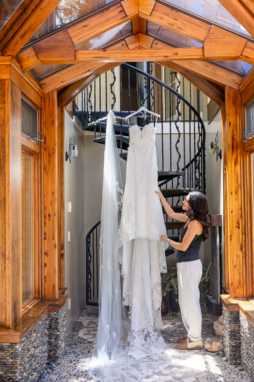 bride looking at her dress in a spiral staircase