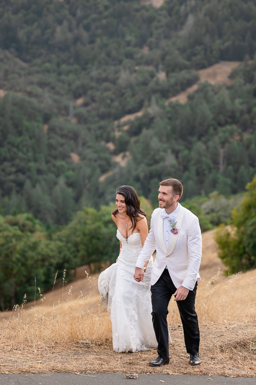 newlyweds hiking up a small hill together