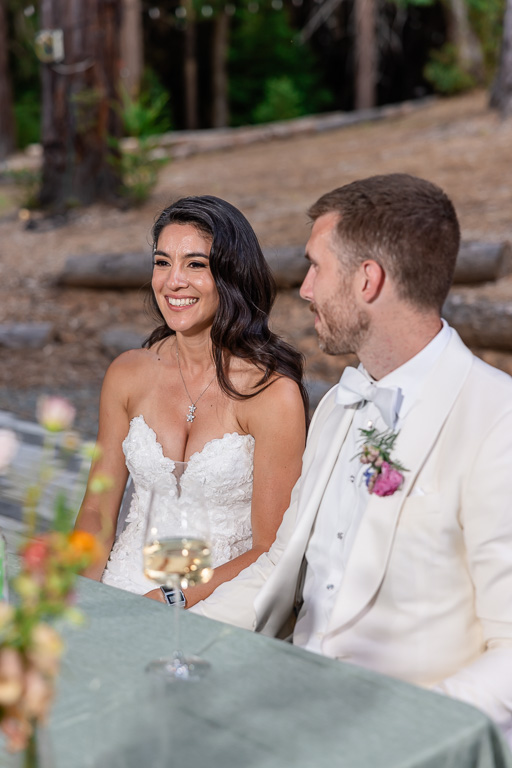 bride and groom at the sweetheart table during speeches
