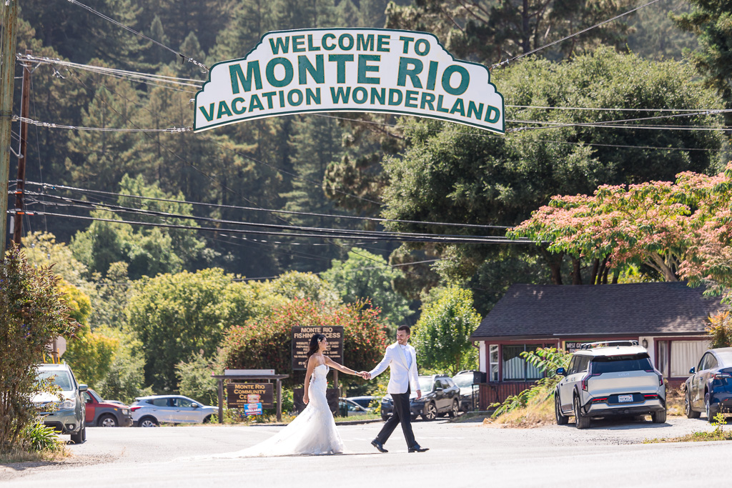 wedding photo under huge Welcome to Monte Rio Vacation Wonderland sign