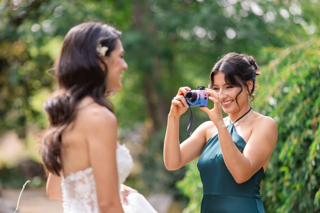 sister taking photos of the bride with a point-and-shoot camera