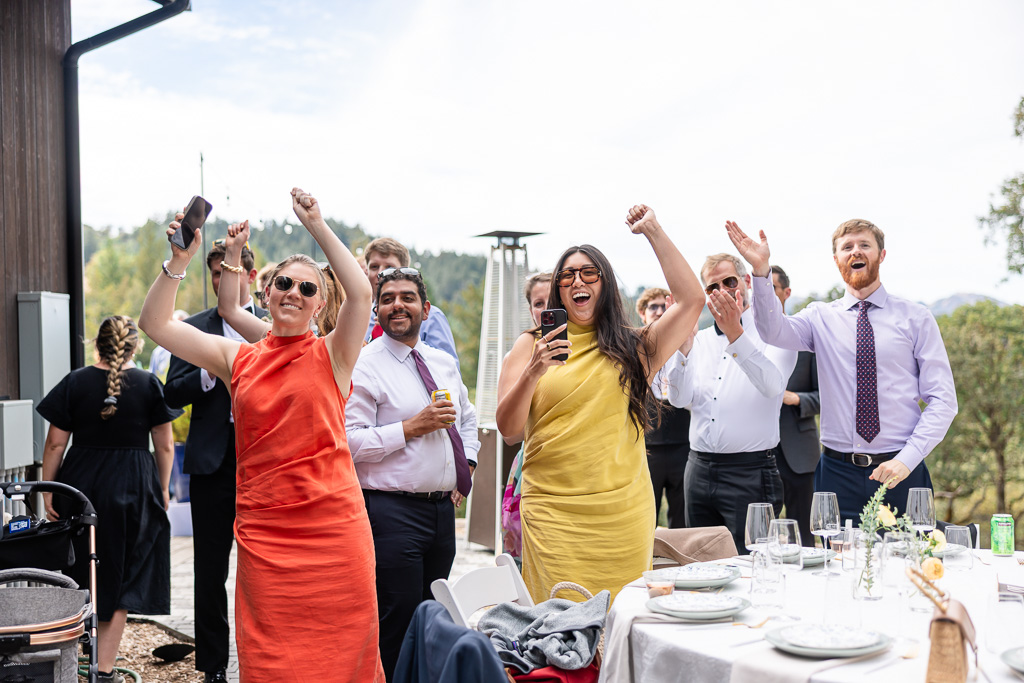 colorfully-dressed guests welcoming the bride and groom into their reception