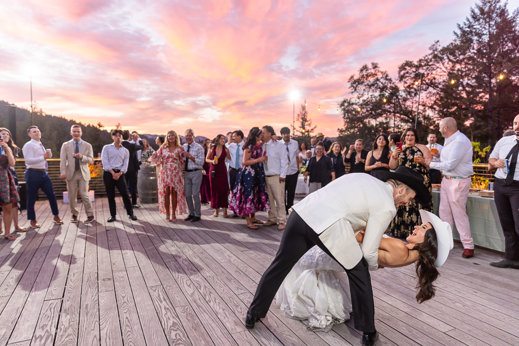 dip & kiss under a dramatic colorful pink sunset sky