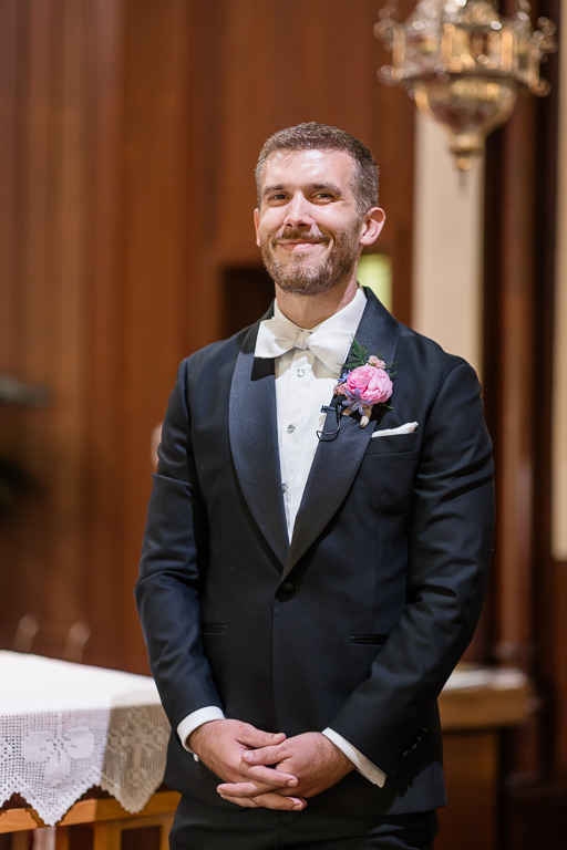 groom looking on as bride walks down the aisle