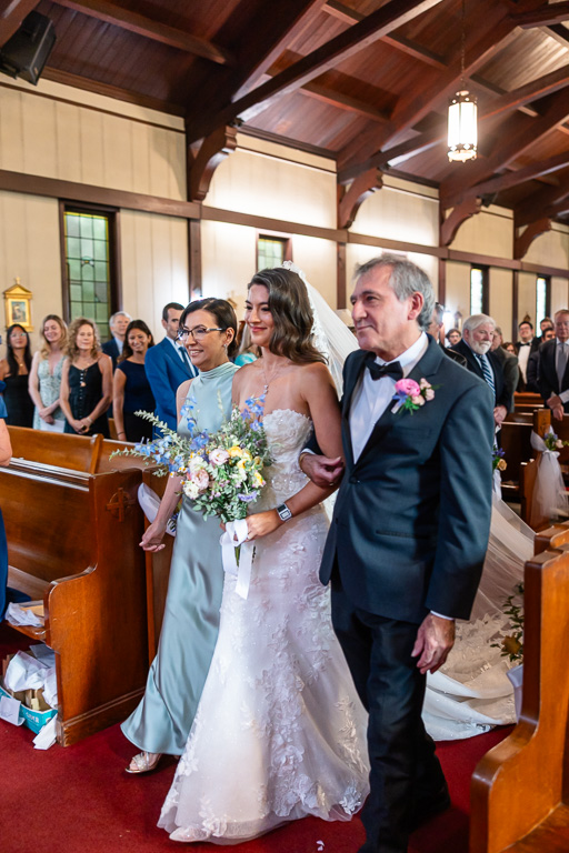 parents of the bride delivering the bride to the end of the aisle