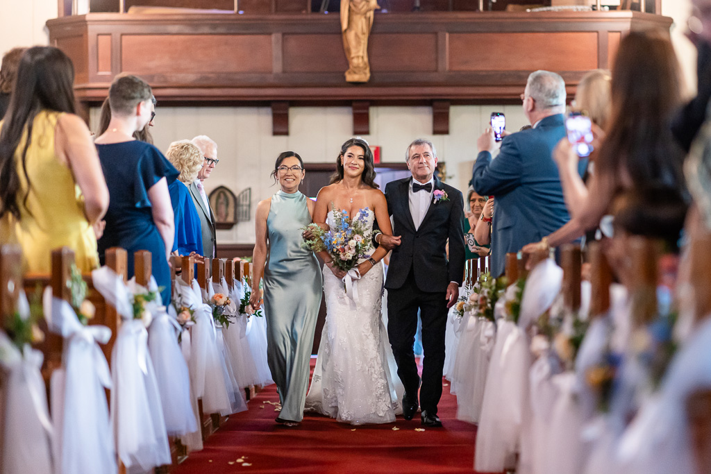 bride walking into St Elizabeth's Roman Catholic Church with one parent on each side