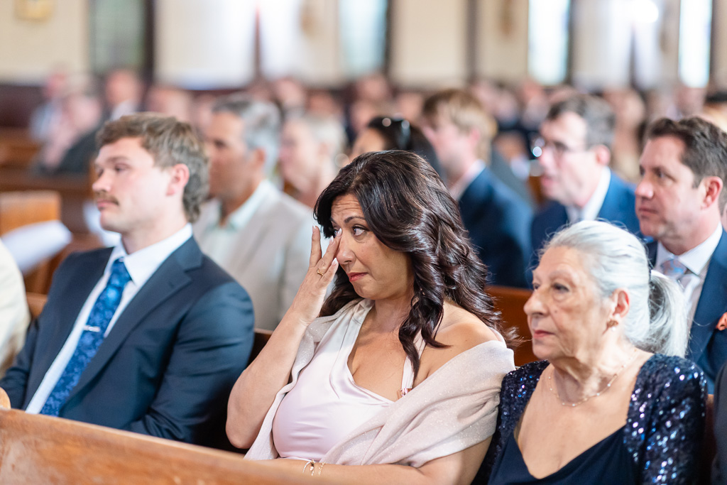 a wedding guest wiping away a tear in the audience
