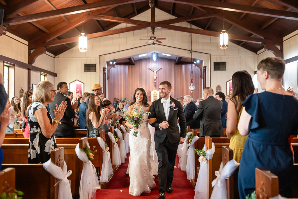 newlyweds walking back up the aisle at St Elizabeth's Roman Catholic Church