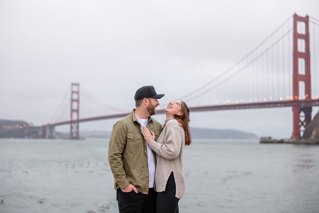 candid engagement photo at the Golden Gate Bridge