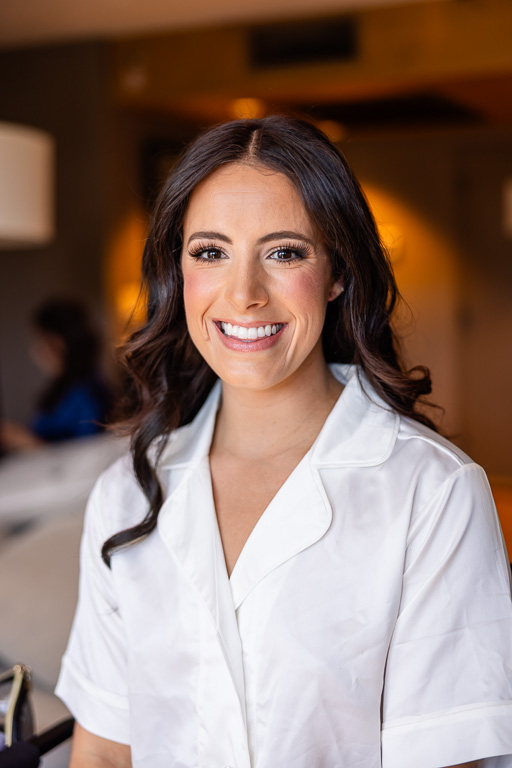 Bride smiles in a white getting-ready outfit before the ceremony