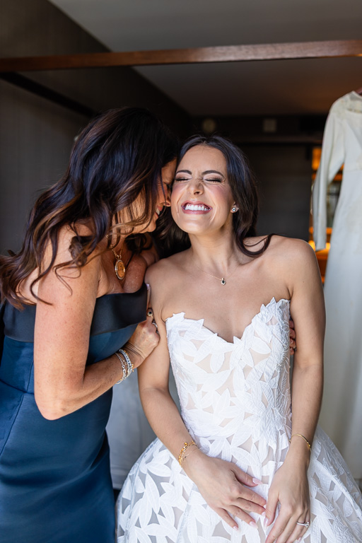 mom kisses the bride on the cheek as she gets ready