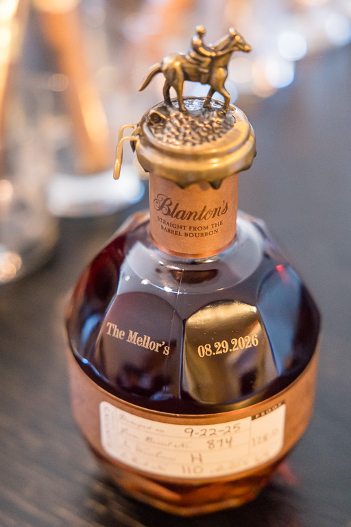 custom monogrammed bottle of bourbon displayed among the wedding details