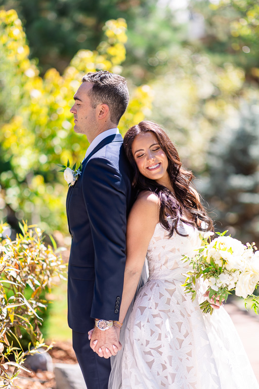 Bride and groom pose together in the water garden for their wedding first touch