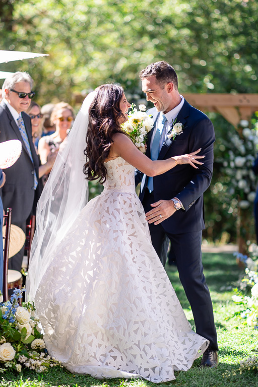Bride and groom smile together as they prepare to dip